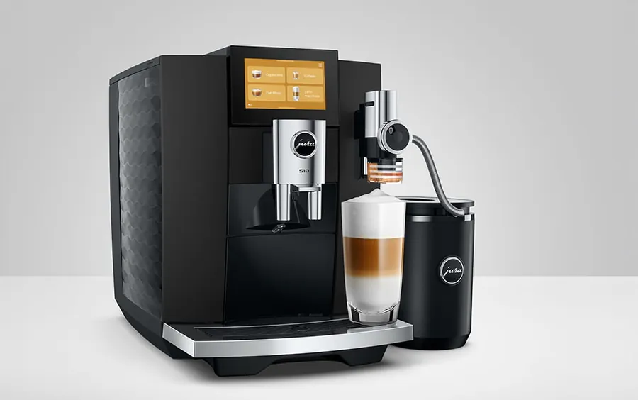 JURA S10 in black with touchscreen, milk container and a layered milk coffee in a glass